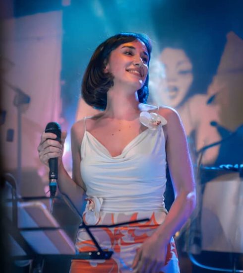 Milica Dobrić peva na sceni držeći mikrofon tokom nastupa.