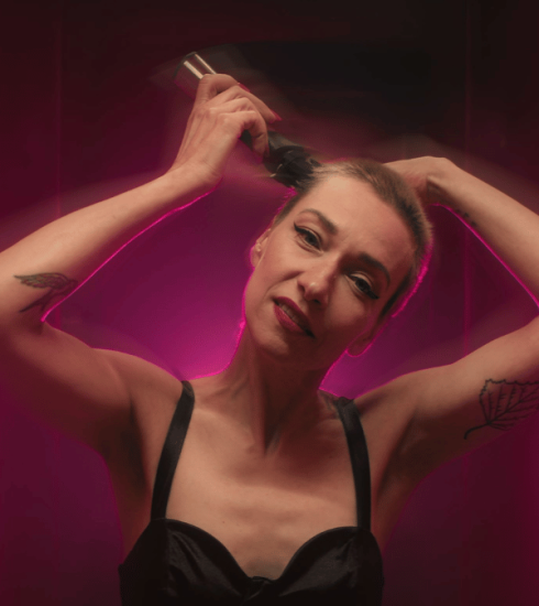 Portret Mirele Priselac REMI dok gleda u kameru i šiša kosu sa glave